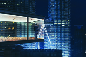 Businessman in an modern sky office by night with beautiful city skyline view .